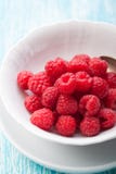 Fresh raspberries in a white ceramic bowl with metal spoon. Closeup, selective focus Stock Photos Fresh raspberries in a white ceramic bowl with metal spoon. Closeup, selective focus Stock Photos
