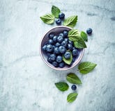 Fresh Ripe Blueberries With Mint Leaves In A Bowl On Gray Marble Background. Symbolic Image. Concept For Healthy Nutrition. Royalty Free Stock Image Fresh Ripe Blueberries With Mint Leaves In A Bowl On Gray Marble Background. Symbolic Image. Concept For Healthy Nutrition. Royalty Free Stock Image
