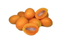 Fresh ripe yellow orange color Marian Plums whole fruits and cut in half fruits with purple seed on white background royalty free stock photography Fresh ripe yellow orange color Marian Plums whole fruits and cut in half fruits with purple seed on white background royalty free stock photography