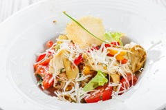 Fresh salad with chicken breast, artichokes, cherry tomatoes, lettuce and cheese parmesan on wooden background close up Royalty Free Stock Photography Fresh salad with chicken breast, artichokes, cherry tomatoes, lettuce and cheese parmesan on wooden background close up Royalty Free Stock Photography