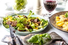 Fresh salad plate with mixed greens arugula, mesclun, mache on dark wooden background close up. MANZO. stock image Fresh salad plate with mixed greens arugula, mesclun, mache on dark wooden background close up. MANZO. stock image