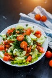 Fresh spring vegetable salad from tomato and cucumber on a black background, close up. stock image Fresh spring vegetable salad from tomato and cucumber on a black background, close up. stock image