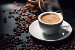 Fresh tasty espresso cup of hot coffee with coffee beans on dark Stock Photo Fresh tasty espresso cup of hot coffee with coffee beans on dark Stock Photo