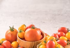 Fresh yellow and red cherry tomatoes in a basket on a cement board, close up, copy space, top view royalty free stock photography Fresh yellow and red cherry tomatoes in a basket on a cement board, close up, copy space, top view royalty free stock photography