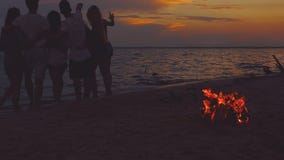 Freunde nähern sich Meer bei Sonnenuntergang stock video Freunde nähern sich Meer bei Sonnenuntergang stock video