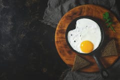 Fried Egg In The Pan. Dark Background, Copy Space. Toned Photo Royalty Free Stock Image