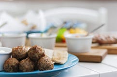 Fried meatballs with white sauce and flat cakes - traditional Greek lunch on a blue plate in a restaurant royalty free stock image Fried meatballs with white sauce and flat cakes - traditional Greek lunch on a blue plate in a restaurant royalty free stock image