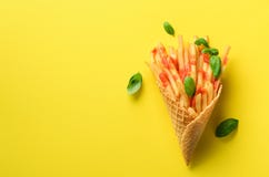 Fried Potatoes In Waffle Cones On Yellow Background. Hot Salty French Fries With Sauce, Basil Leaves. Fast Food, Junk Royalty Free Stock Images