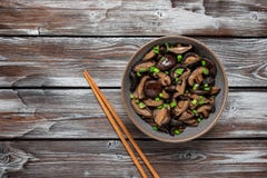 Fried Shiitake Mushrooms With Green Onions In A Bowl On A Wooden Old Background. Japanese Vegetarian Food. Top View Stock Photos Fried Shiitake Mushrooms With Green Onions In A Bowl On A Wooden Old Background. Japanese Vegetarian Food. Top View Stock Photos