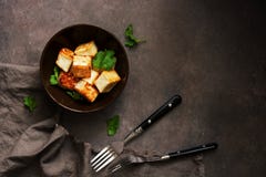 Fried Tofu Cheese In A Bowl With Greens On A Dark Background. Top View, Copy Space Royalty Free Stock Image