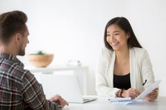Friendly asian hr smiling talking to candidate at job interview