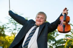 Friendly handicapped boy raising violin outdoors. stock photography Friendly handicapped boy raising violin outdoors. stock photography