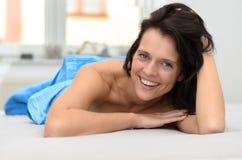 Friendly happy young woman lying on her bed stock images Friendly happy young woman lying on her bed stock images