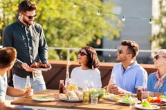 Friends at bbq party on rooftop in summer royalty free stock images Friends at bbq party on rooftop in summer royalty free stock images