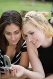 Friends On Cell Phone Together (Beautiful Young Blonde And Brunette Girls) Stock Photography