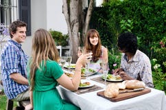 Friends at a outdoor party in the garden with food and drink Royalty Free Stock Images Friends at a outdoor party in the garden with food and drink Royalty Free Stock Images