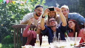 Friends taking selfie at party in summer garden