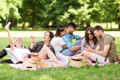 Friends with smartphones on picnic at summer park stock photos Friends with smartphones on picnic at summer park stock photos