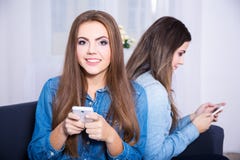 Friendship and phone addiction concept - two young women using t royalty free stock image Friendship and phone addiction concept - two young women using t royalty free stock image