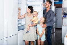 Frigorifero nuovo di compera di famiglia di quattro nel deposito dell'elettrodomestico immagini stock libere da diritti Frigorifero nuovo di compera di famiglia di quattro nel deposito dell'elettrodomestico immagini stock libere da diritti