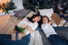 Frohe Weihnachten und frohe Feiertage Nette Mutter und ihr nettes Tochtermädchen, die Geschenke austauscht Elternteil und kleines stockbilder Frohe Weihnachten und frohe Feiertage Nette Mutter und ihr nettes Tochtermädchen, die Geschenke austauscht Elternteil und kleines stockbilder