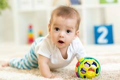 Frohes Baby, das auf den Boden im Kindertagesstättenraum kriecht stockbilder Frohes Baby, das auf den Boden im Kindertagesstättenraum kriecht stockbilder