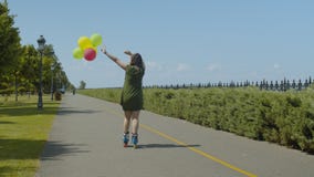 Frohes Frauenrollenreiten mit Ballonen draußen stock footage Frohes Frauenrollenreiten mit Ballonen draußen stock footage