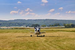Front view of Cessna 172 airplane standing on grass field with blue cloudy sky on the background. royalty free stock photo Front view of Cessna 172 airplane standing on grass field with blue cloudy sky on the background. royalty free stock photo