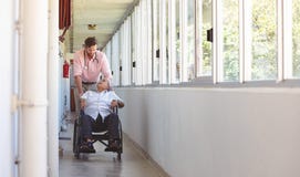Male doctor pushing senior wheelchair man stock photo Male doctor pushing senior wheelchair man stock photo
