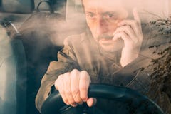 Front view of man driving car and talking on mobile stock photography Front view of man driving car and talking on mobile stock photography