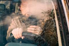 Front view of man driving car and texting on mobile royalty free stock photo Front view of man driving car and texting on mobile royalty free stock photo