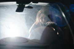 Front View Portrait de belle femme conduisant sa voiture de luxe la nuit Les feux de signalisation derrière photos stock Front View Portrait de belle femme conduisant sa voiture de luxe la nuit Les feux de signalisation derrière photos stock