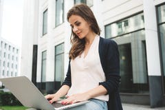 Front view of woman student is work on laptop keyboard on outdoors in urban stock images Front view of woman student is work on laptop keyboard on outdoors in urban stock images