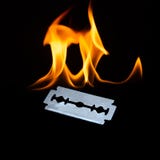 Photography of a shiny sharp razor blade with flames royalty free stock image Photography of a shiny sharp razor blade with flames royalty free stock image