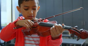 Frontowy widok baczny Azjatycki uczniowski bawić się skrzypce w sali lekcyjnej przy szkołą 4k zdjęcie wideo Frontowy widok baczny Azjatycki uczniowski bawić się skrzypce w sali lekcyjnej przy szkołą 4k zdjęcie wideo