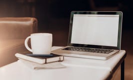 Frontowy widok pusty miejsce pracy Na białym stolik do kawy jest laptop z pustym ekranem, filiżanka kawy, notatnik, pióro, gazeta Zdjęcie Royalty Free Frontowy widok pusty miejsce pracy Na białym stolik do kawy jest laptop z pustym ekranem, filiżanka kawy, notatnik, pióro, gazeta Zdjęcie Royalty Free