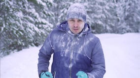 Frozen male athlete runs through the snowy forest, winter activity