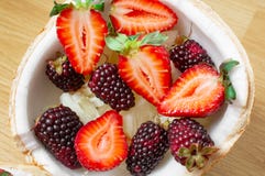 Fruit salad, berries, strawberries, blackberries, ananas in coconut. On the wooden floor. royalty free stock photos Fruit salad, berries, strawberries, blackberries, ananas in coconut. On the wooden floor. royalty free stock photos