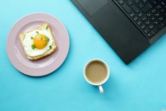 Frukost och bärbar dator på blå bakgrund royaltyfria foton Frukost och bärbar dator på blå bakgrund royaltyfria foton