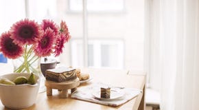 Frukost på tabellen vid fönstret En bukett av blommor och kaffe den antika koppen för affärskaffeavtalet danade för pennplatsen f arkivbilder Frukost på tabellen vid fönstret En bukett av blommor och kaffe den antika koppen för affärskaffeavtalet danade för pennplatsen f arkivbilder