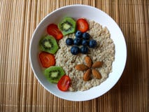 Frukostbunke med jordgubbar, kiwi och blåbär, med sädesslag och mandlar som bildar en blomma royaltyfri fotografi Frukostbunke med jordgubbar, kiwi och blåbär, med sädesslag och mandlar som bildar en blomma royaltyfri fotografi