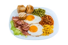 Frukosten stekte äggärtor, havrekorn, bönor och stekt bacon på en vit platta arkivfoto Frukosten stekte äggärtor, havrekorn, bönor och stekt bacon på en vit platta arkivfoto