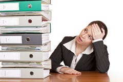 Frustrated Business Woman Looks At Folder Stack Stock Image