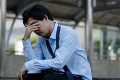 Frustrated stressed young Asian businessman touching head and feeling tired and exhausted with his job royalty free stock photography Frustrated stressed young Asian businessman touching head and feeling tired and exhausted with his job royalty free stock photography