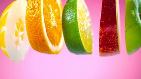 Frutas cortadas que caen en chapoteo del agua imágenes de archivo libres de regalías Frutas cortadas que caen en chapoteo del agua imágenes de archivo libres de regalías