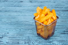 Frytki i kukurudza wtykają w żelaznym koszu na drewnianym tle zdjęcie stock Frytki i kukurudza wtykają w żelaznym koszu na drewnianym tle zdjęcie stock