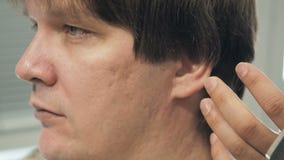 Fryzjer ciie włosy na ucho i świątyni klient w salonie Mężczyzna obsiadanie w fryzjera karle podczas gdy shearing zbiory wideo Fryzjer ciie włosy na ucho i świątyni klient w salonie Mężczyzna obsiadanie w fryzjera karle podczas gdy shearing zbiory wideo