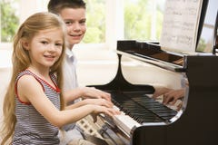 Frère et soeur jouant le piano image stock Frère et soeur jouant le piano image stock