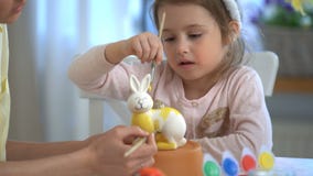 Fröhliche Ostern! Bemuttern Sie und ihre kleine Tochter mit den Häschenohren, die Osterhasen malen stock footage Fröhliche Ostern! Bemuttern Sie und ihre kleine Tochter mit den Häschenohren, die Osterhasen malen stock footage
