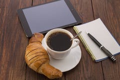 Frühstücken Sie mit Schale des schwarzen Kaffees, der Hörnchen und des Notizbuches lizenzfreies stockbild Frühstücken Sie mit Schale des schwarzen Kaffees, der Hörnchen und des Notizbuches lizenzfreies stockbild